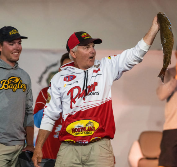 John Peterson showing off a smallmouth on stage.