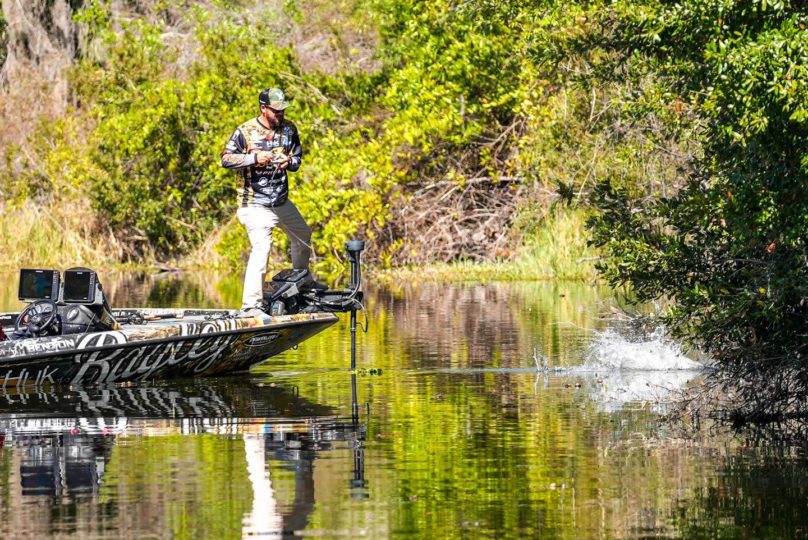 Drew Benton battling a largemouth bass to the boat