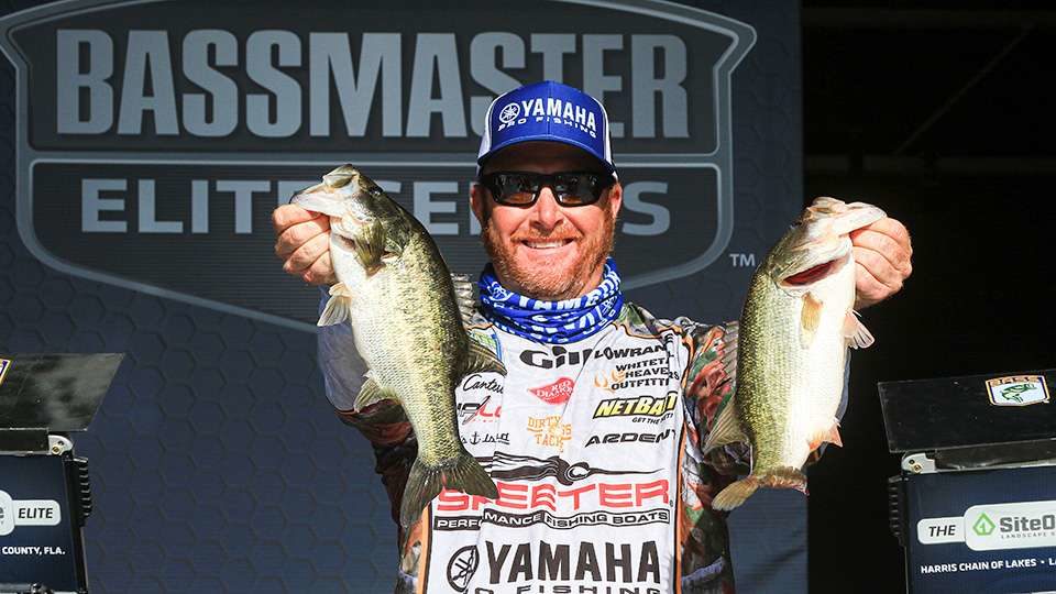 Scott Canterbury holding up two largemouth bass on stage