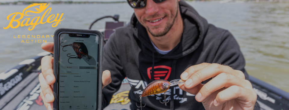 man shows fishing lure and phone screen of bait app